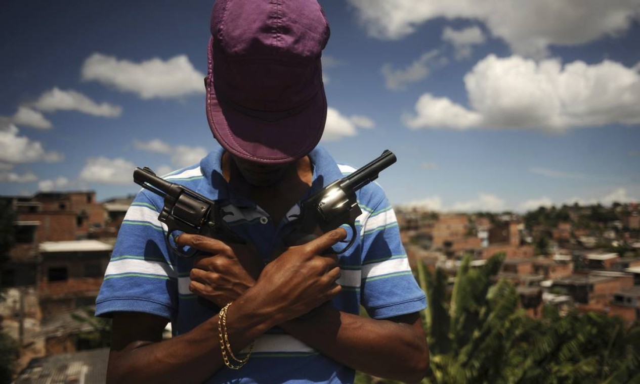 Numa das favelas de Salvador, o traficante conhecido como “Veneno” mostra parte do arsenal Foto: LUNAE PARRACHO / REUTERS