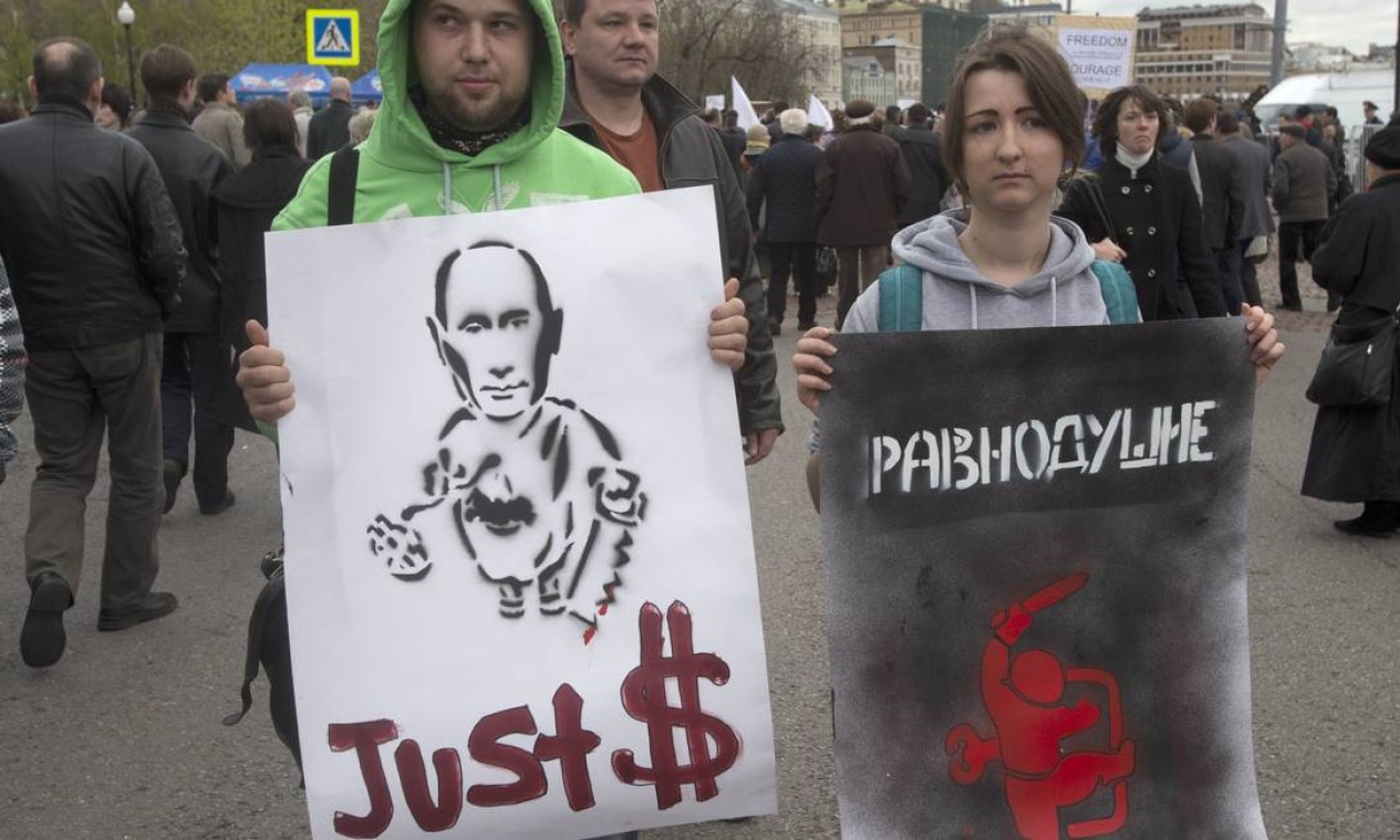 Cartazes fazem denúncias sobre suposto enriquecimento ilícito de Putin Foto: Misha Japaridze / AP