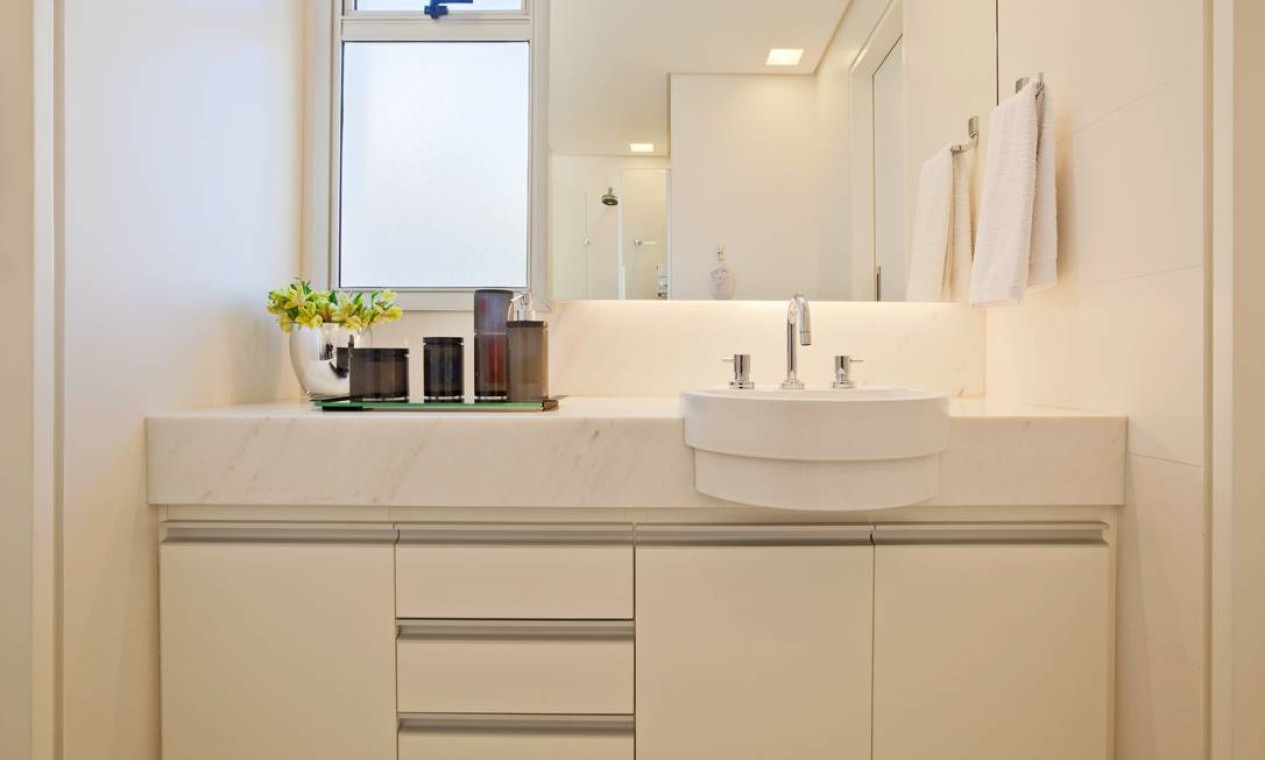 O banheiro seguiu a estética minimalista, com predomínio da cor branca, no mármore e na cerâmica retificada Foto: Divulgação