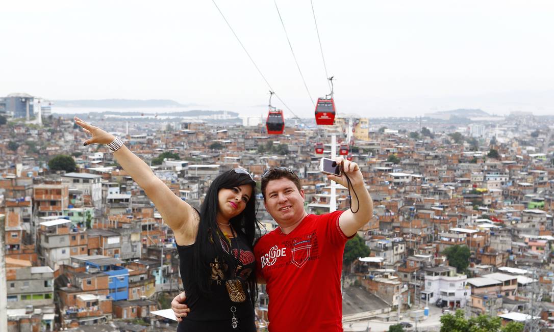 
O casal gaúcho, Sheila e Guto Alves, faz pose para o famoso clique com a favela e o teleférico
Foto: Pablo Jacob / O Globo
