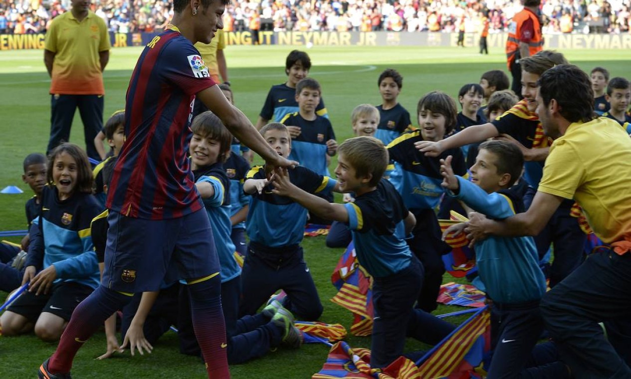 FC Barcelona's new player Brazilian Neymar da Silva Santos Junior (L) highfives young supporters during his presentation at Camp Nou stadium in Barcelona, on June 3, 2013. Santos and Brazil star Neymar signed a five-year contract with Spanish giants Barcelona. AFP PHOTO/ LLUIS GENE Foto: LLUIS GENE / AFP