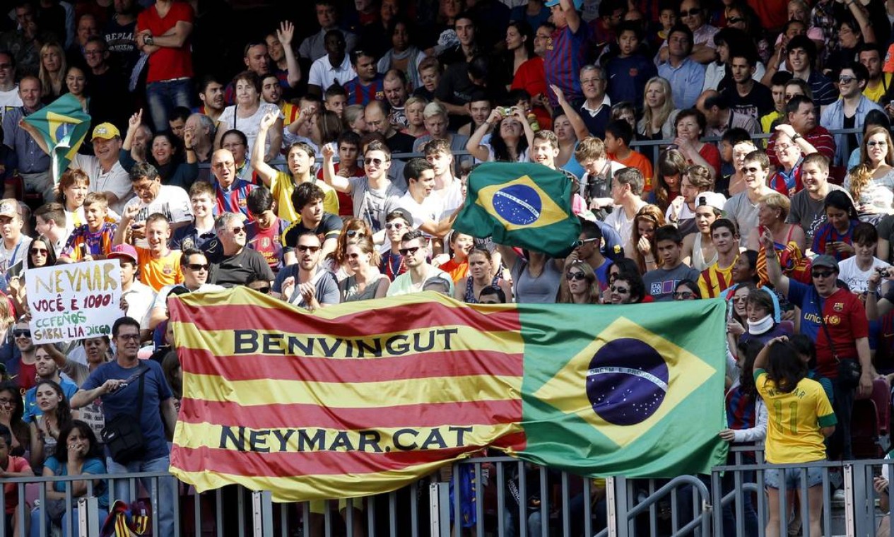 Barcelona's supporters hold up a banner bearing the Catalan and Brazilian flags before Brazilian soccer player Neymar's presentation after he signed a five-year contract with the club, at Nou Camp stadium in Barcelona June 3, 2013. The banner reads "Welcome, Neymar". REUTERS/Gustau Nacarino (SPAIN - Tags: SPORT SOCCER) Foto: GUSTAU NACARINO / REUTERS
