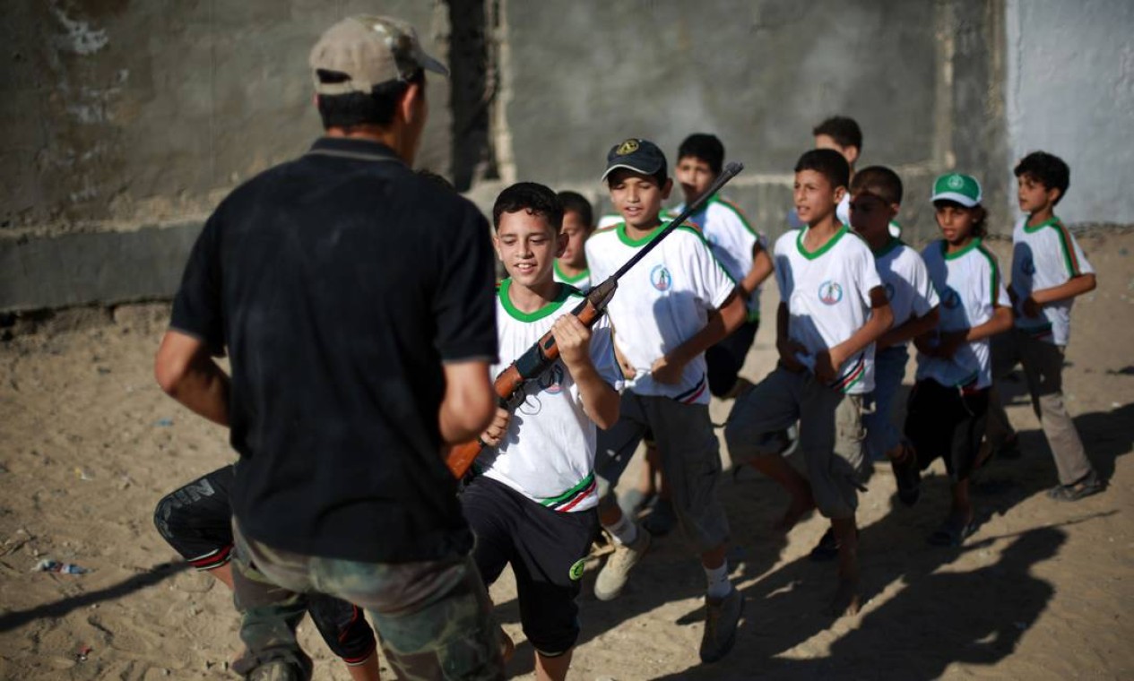 Garotos palestinos passam parte de suas férias de verão treinando em acampamentos do Hamas na Faixa de Gaza. No local, eles aprendem a manusear armas Foto: MOHAMMED ABED / AFP