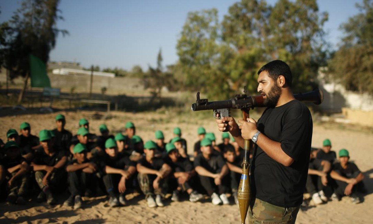 Um militante do Hamas ensina jovens palestinos como usar um lança-granadas Foto: MOHAMMED SALEM / REUTERS