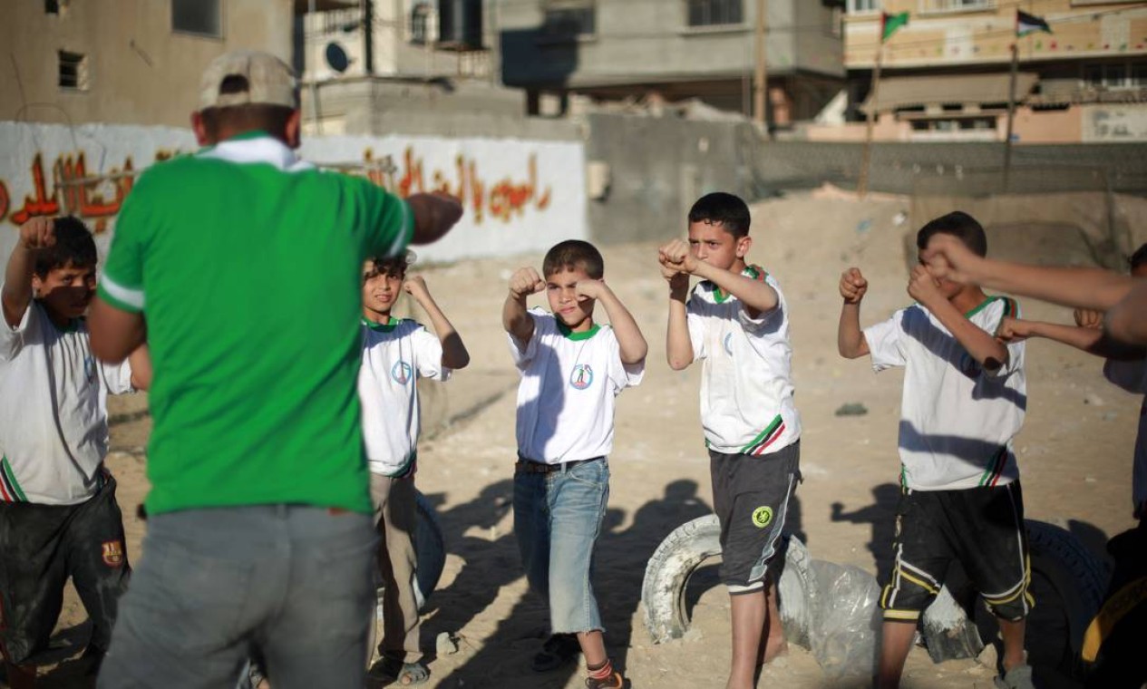 As crianças de Gaza que vão para a colônia de férias ainda aprendem lições sobre o Islã, doutrinação política e, em alguns casos, até treinamento paramilitar Foto: MOHAMMED ABED / AFP