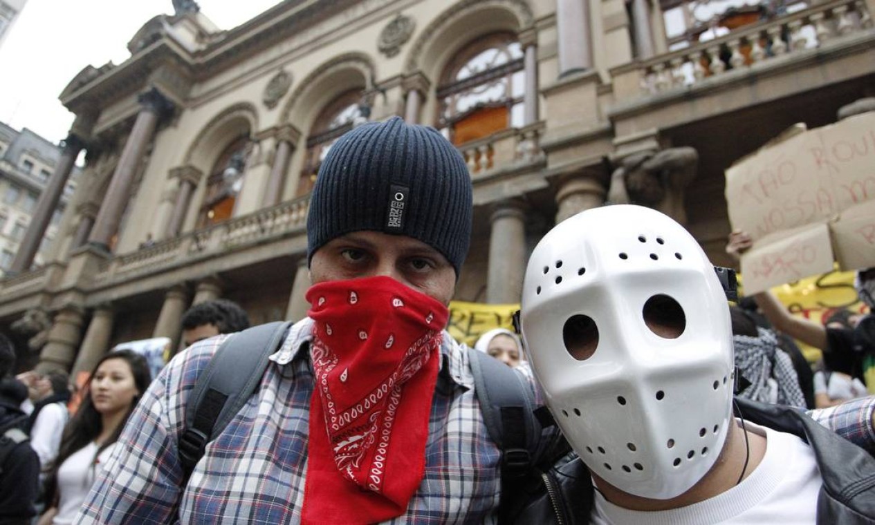 Estudantes escondem o rosto na manifestação contra o aumento das tarifas Foto: ELIARIA ANDRADE / Agência O Globo