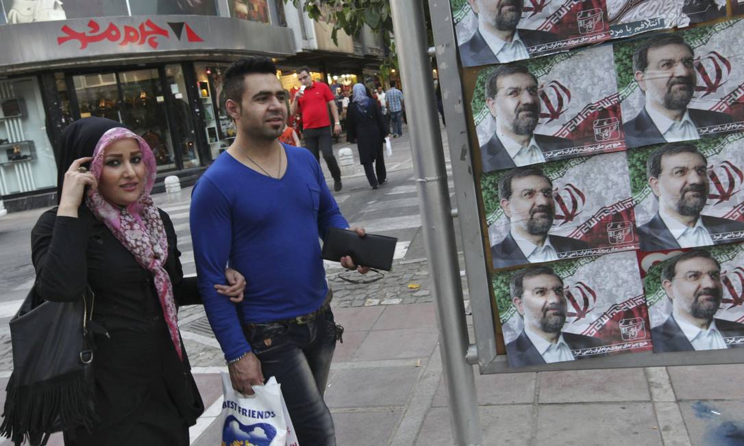 
Iranianos passam por cartaz do candidato Mohsen Rezaei, em Teerã
Foto:
Vahid Salemi
/
AP
