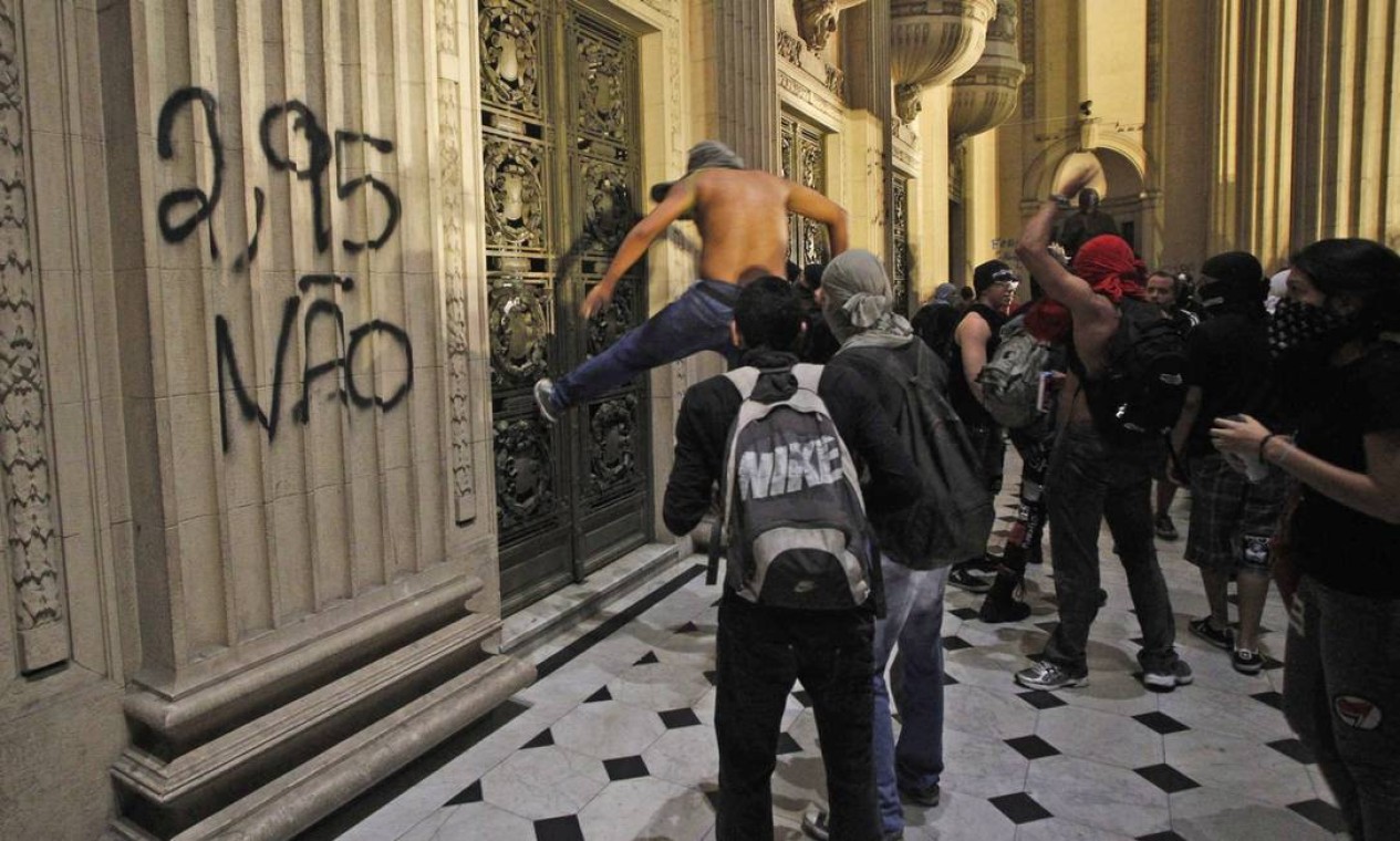 Manifestante chuta a grade da Alerj: prédio da assembleia foi pichado Foto: Pedro Kirilos / Agência O Globo