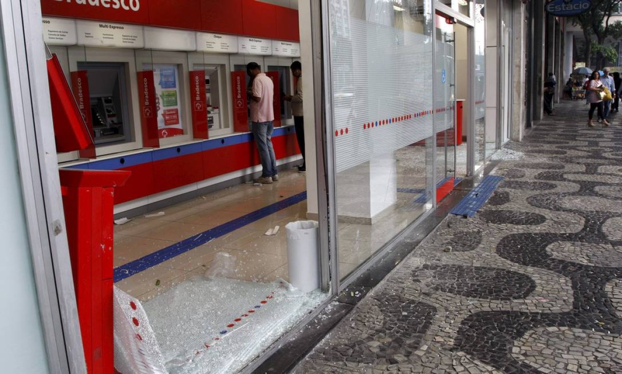 Vidraça de uma das agências bancárias foi completamente quebrada Foto: Marcos Tristão / Agência O Globo