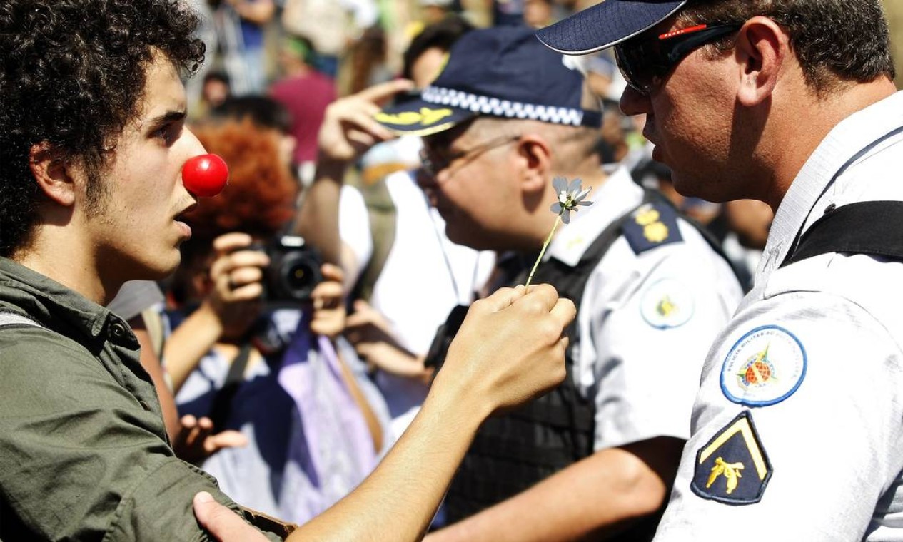 Manifestante oferece flor a policial durante o protesto Foto: BETO BARATA / AFP