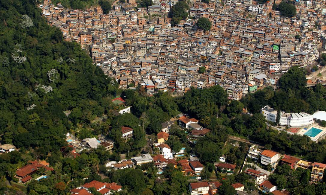 
O bairro da Gávea e a Rocinha, vistos do alto, são os dois lados de uma cidade que, agora, assiste a uma transformação na economia das favelas
Foto: Custódio Coimbra / Agência O Globo