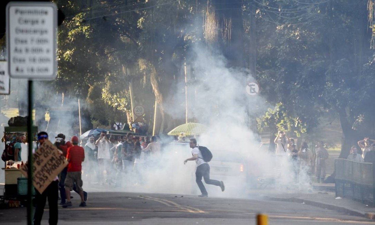 Manifestante corre após a explosão de uma bomba de gás lacrimogêneo Foto: Pedro Kirilos / Agência O Globo
