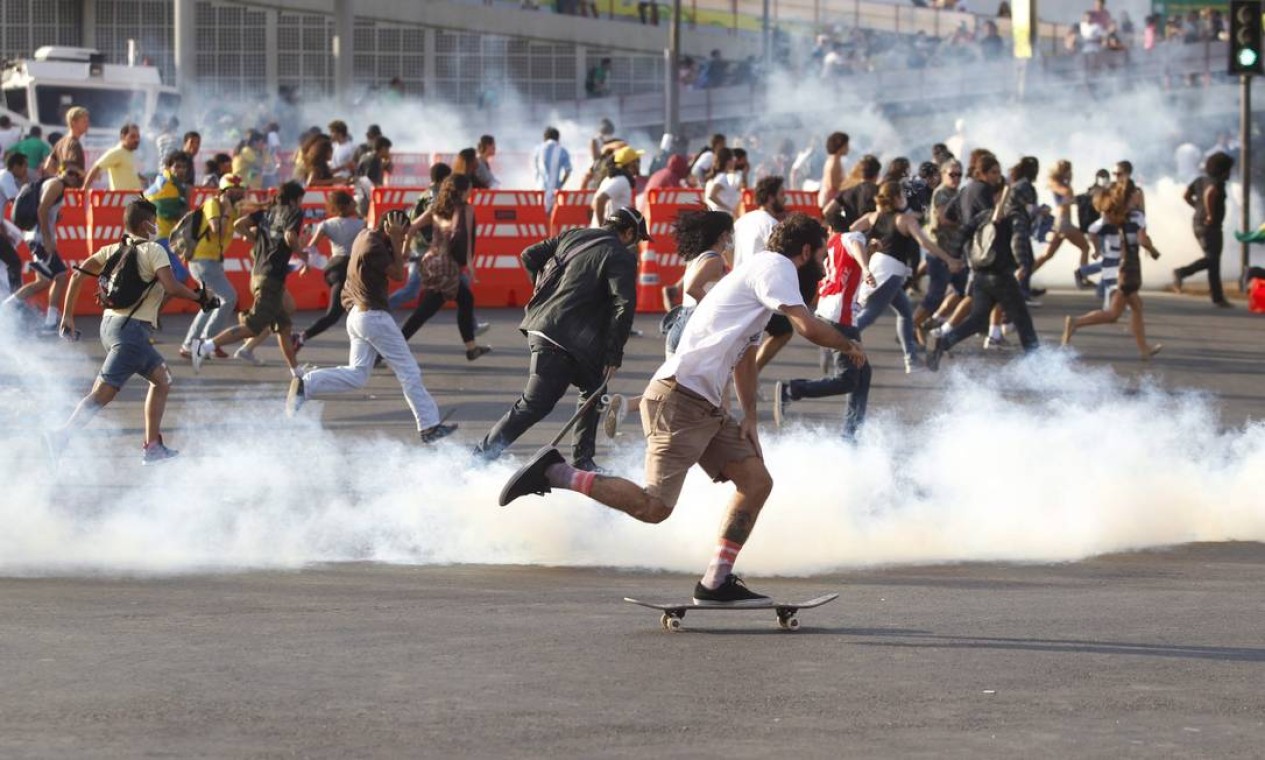Manifestante foge em cima de um skate de uma bomba de gás lacrimogêneo atirada pela Tropa de Choque da Polícia Militar Foto: Pedro Kirilos / Agência O Globo