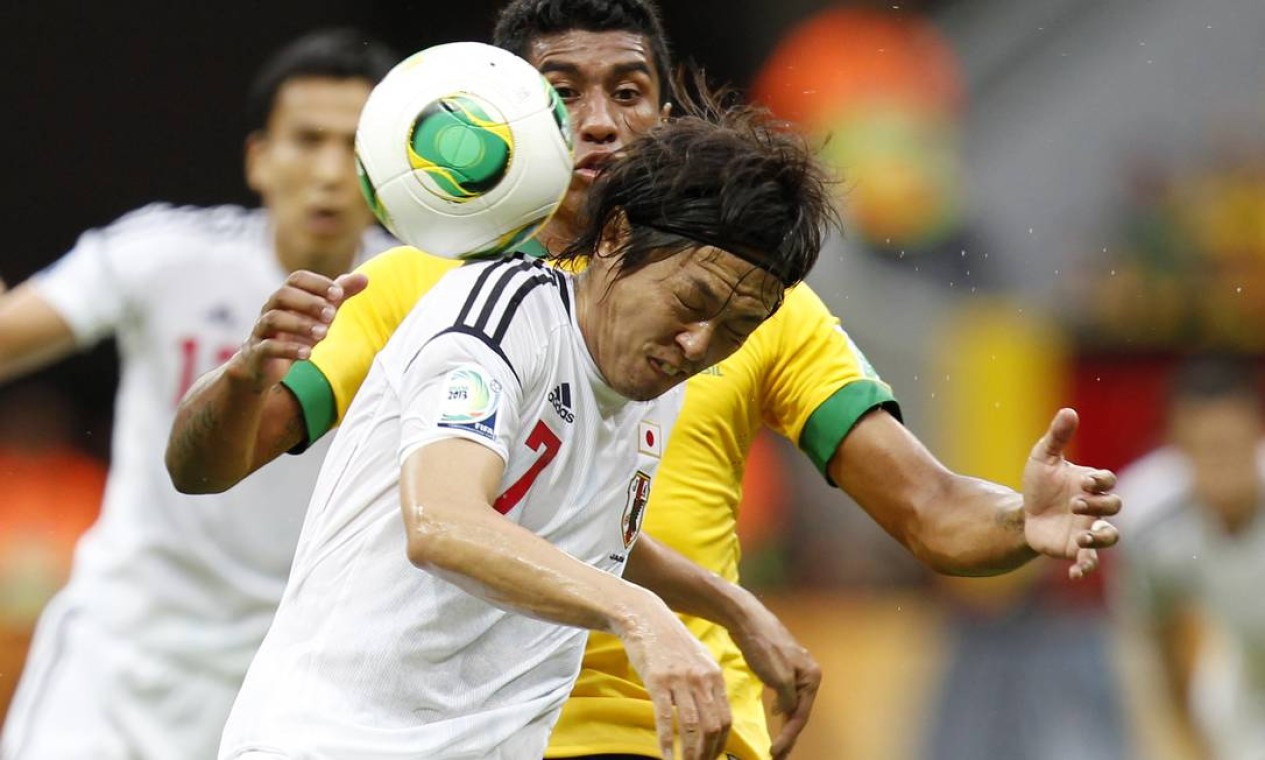 Brazil's Paulinho, back, and Japan's Yasuhito Endo challenge for the ball during the opening match between Brazil and Japan in group A of the soccer Confederations Cup at the National Stadium in Brasilia, Brazil, Saturday, June 15, 2013. (AP Photo/Eugene Hoshiko) Foto: Eugene Hoshiko / AP