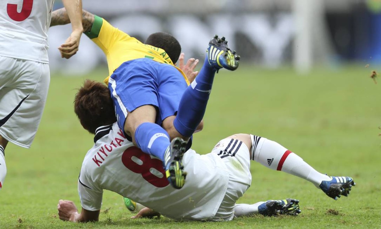 Brazil's Dani Alves, front, falls over Japan's Hiroshi Kiyotake during the opening match between Brazil and Japan in group A of the soccer Confederations Cup at the National Stadium in Brasilia, Brazil, Saturday, June 15, 2013. (AP Photo/Andre Penner) Foto: Andre Penner / AP
