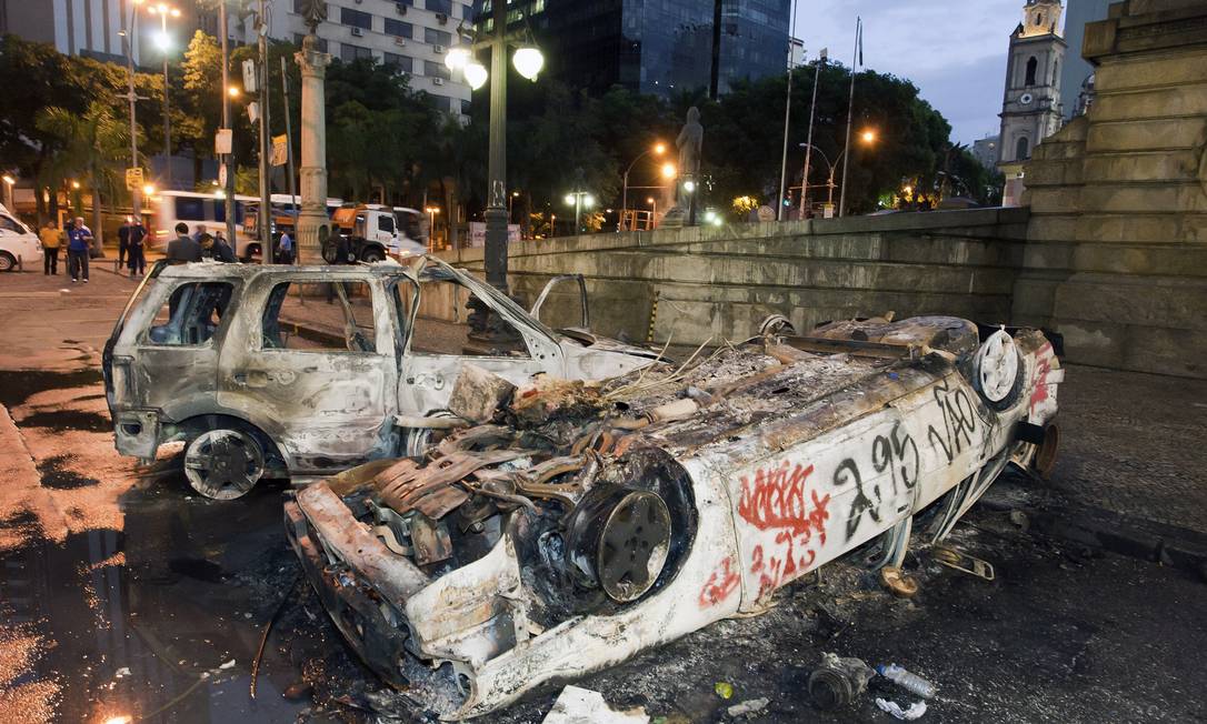Carros que foram queimados no Centro do Rio, durante quebra-quebra entre manifestantes e policiais, amanhecem pichados ao lado da Alerj Foto: Fernando Quevedo / Agência O Globo