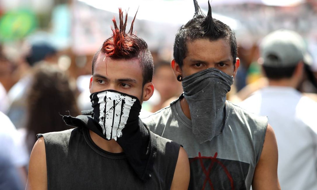 Dois manifestantes cobrem parte do rosto Foto: Ivo Gonzalez / Agência O Globo