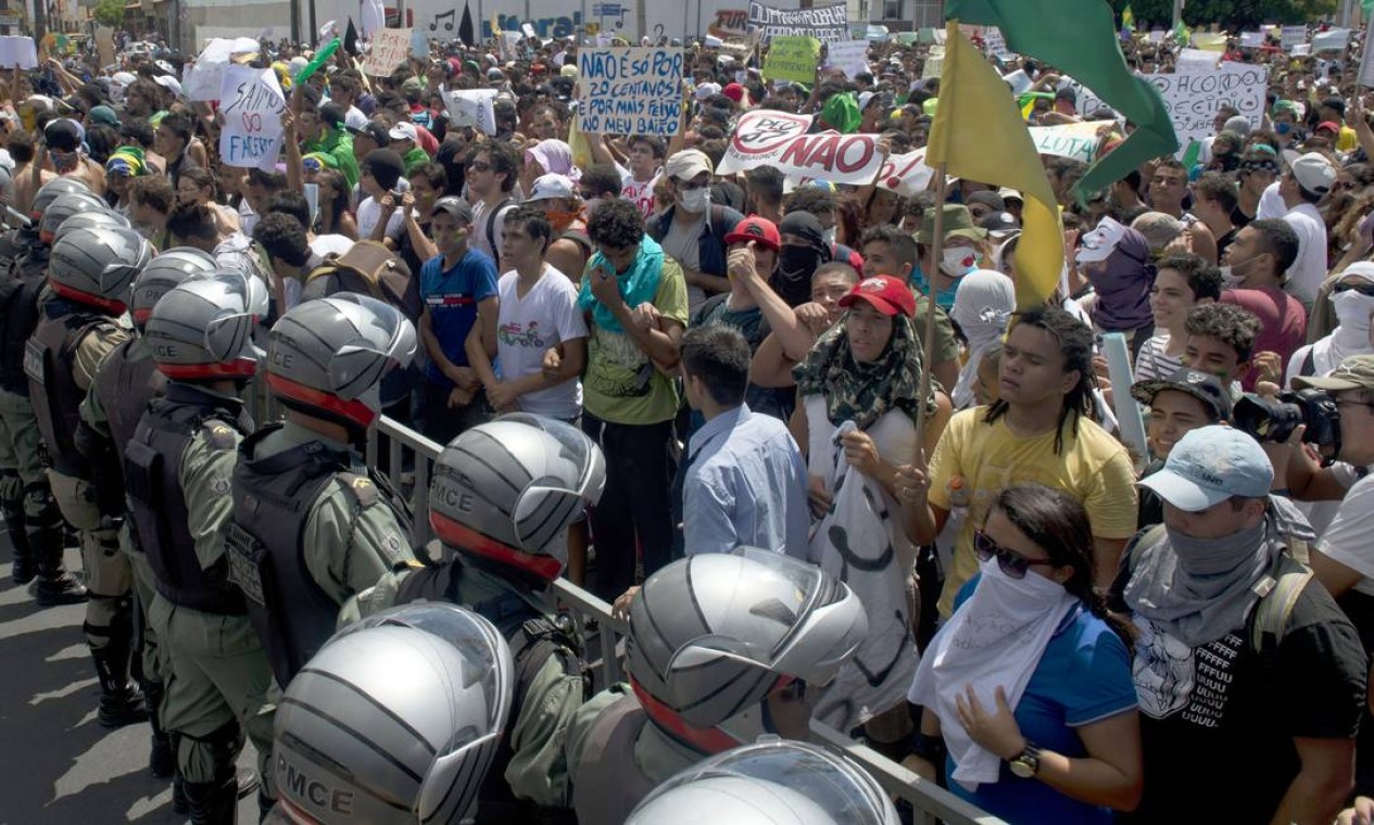 Protesters demonstrate as a group clashes with the riot police while trying to block access to the Castelao Stadium in Fortaleza, where Brazil is to play Mexico in a FIFA Confederations Cup Brazil 2013 football match, to denounce the events' $15 billion price-tag, on June 19, 2013. Some of the roughly 10,000 protesters at the site hurled stones at security forces, who responded with tear gas and rubber bullets. Brazil deployed special federal police Wednesday to protect Confederations Cup venues, as mass "Tropical Spring" protests against government spending for the 2014 World Cup turn violent. AFP PHOTO / YURI CORTEZ Foto: YURI CORTEZ / AFP