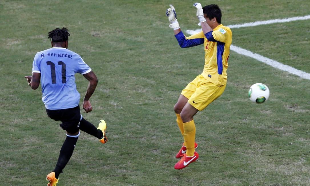 Goleiro do Taiti Gilbert Meriel pula, enquanto Hernandez chuta a bola por baixo de suas pernas Foto: REUTERS