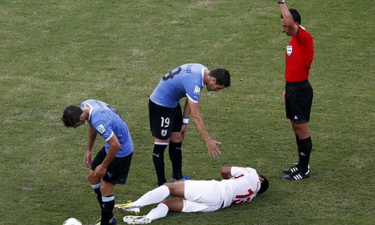 Referee Pedro Proenca of Portugal shows the yellow card to Uruguay's Andres Scotti (C) for a foul on Tahiti's Steevy Chong Hue (on ground) during their Confederations Cup Group B soccer match at the Arena Pernambuco in Recife June 23, 2013. REUTERS/Marcos Brindicci (BRAZIL - Tags: SPORT SOCCER) Foto: MARCOS BRINDICCI / REUTERS