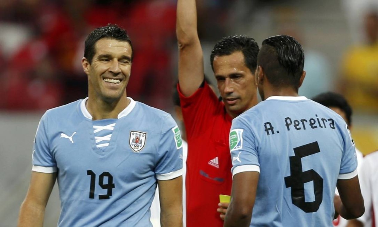 Uruguay's Andres Scotti (L) is shown the red card by referee Pedro Proenca of Portugal during their Confederations Cup Group B soccer match against Tahiti at the Arena Pernambuco in Recife June 23, 2013. REUTERS/Ivan Alvarado (BRAZIL - Tags: SPORT SOCCER) Foto: IVAN ALVARADO / REUTERS