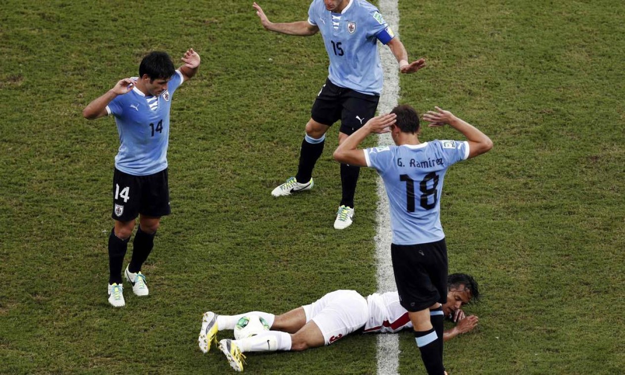 Uruguay's Nicolas Lodeiro (L), Diego Perez and Gaston Ramirez (R) react as Tahiti's Marama Vahirua lies on the ground during their Confederations Cup Group B soccer match at the Arena Pernambuco in Recife June 23, 2013. REUTERS/Marcos Brindicci (BRAZIL - Tags: SPORT SOCCER TPX IMAGES OF THE DAY) Foto: MARCOS BRINDICCI / REUTERS