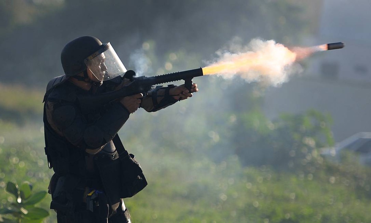 Integrante da Polícia de Choque lança gás lacrimogêneo contra grupo durate protesto em Fortaleza Foto: YASUYOSHI CHIBA / AFP