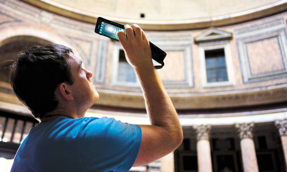 Aplicativos ajudam viajantes. Na foto, turista fotografa com seu smartphone Foto: Domenico Sinellis / AP