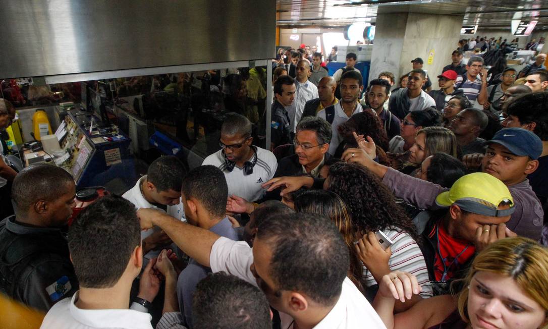 Policial ajuda a conter tumulto na estação Uruguaiana do metrô na tarde de terça-feira Foto: Pedro Kirilos / Agência O Globo