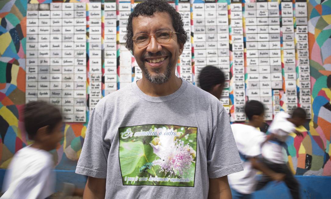 
O professor de biologia Luiz Henrique Rosa em frente ao muro decorado por alunos da Escola Municipal Herbert Moses com cerca de 200 nomes de escravos
Foto: Paula Giolito