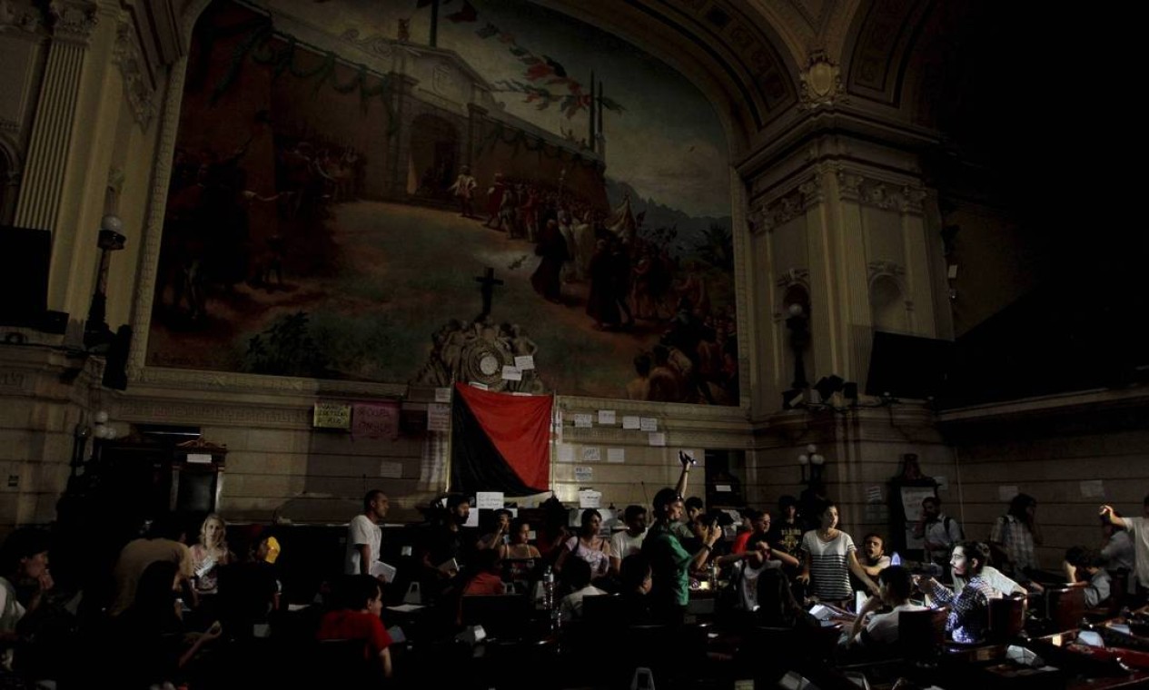 Manifestantes ocupam plenário da Câmara dos Vereadores. Iluminação do local foi cortada Foto: Domingos Peixoto / O Globo