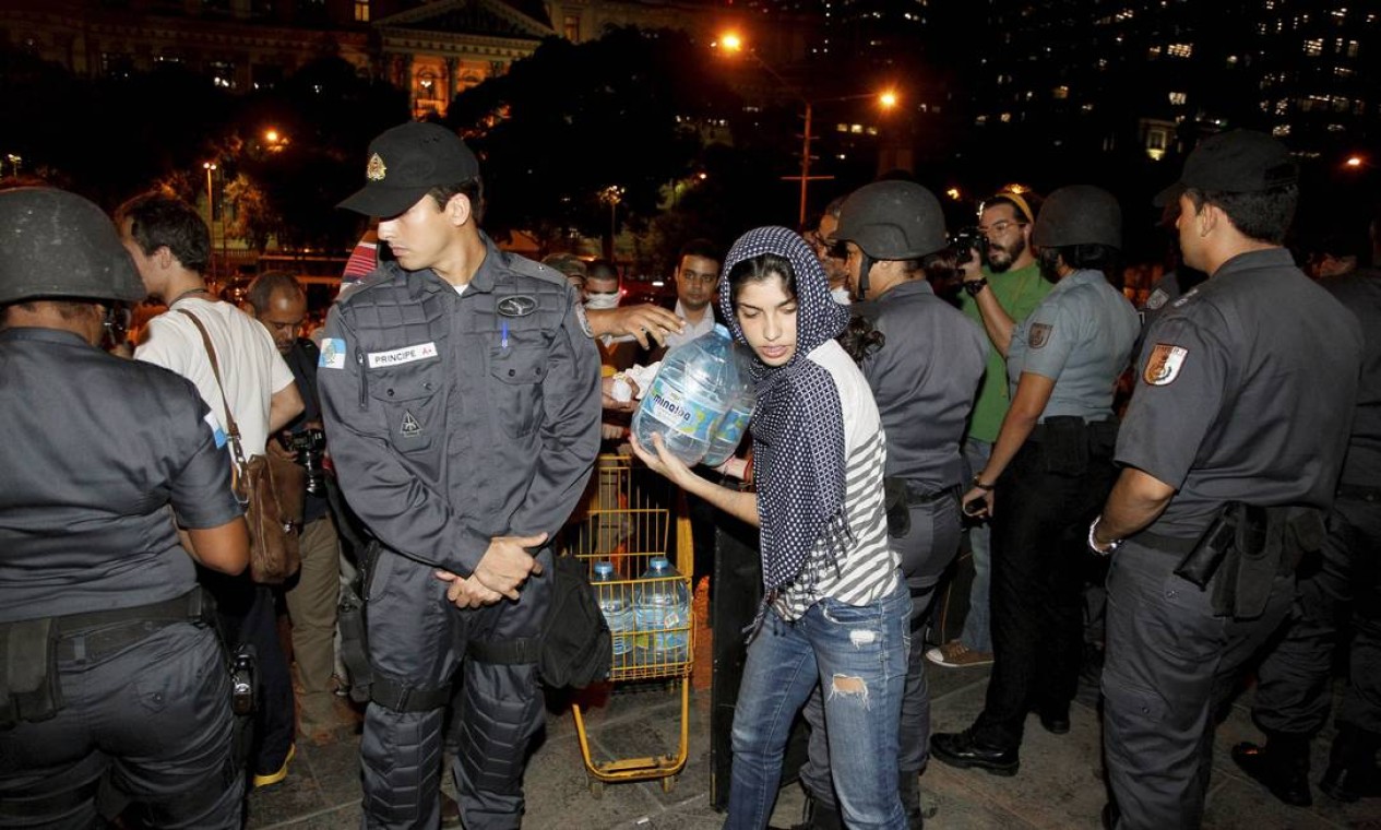 Mulher distribui água para os manifestantes Foto: Domingos Peixoto / Agência O Globo