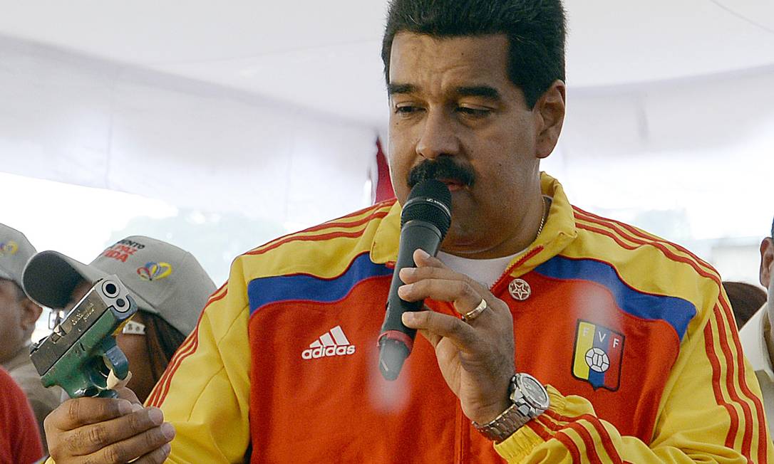 
Nicolás Maduro observa uma arma enquanto discursa durante um evento para promover um programa de desarmamento público
Foto: JUAN BARRETO / AFP