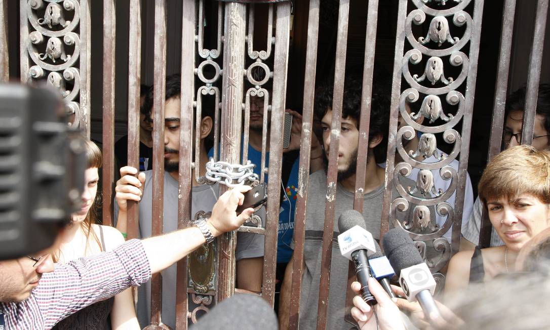 Atrás do portão principal da Câmara, manifestantes que ocuparam a Câmara do vereadores dão entrevista para a imprensa Foto: O Globo / Marcos Tristão