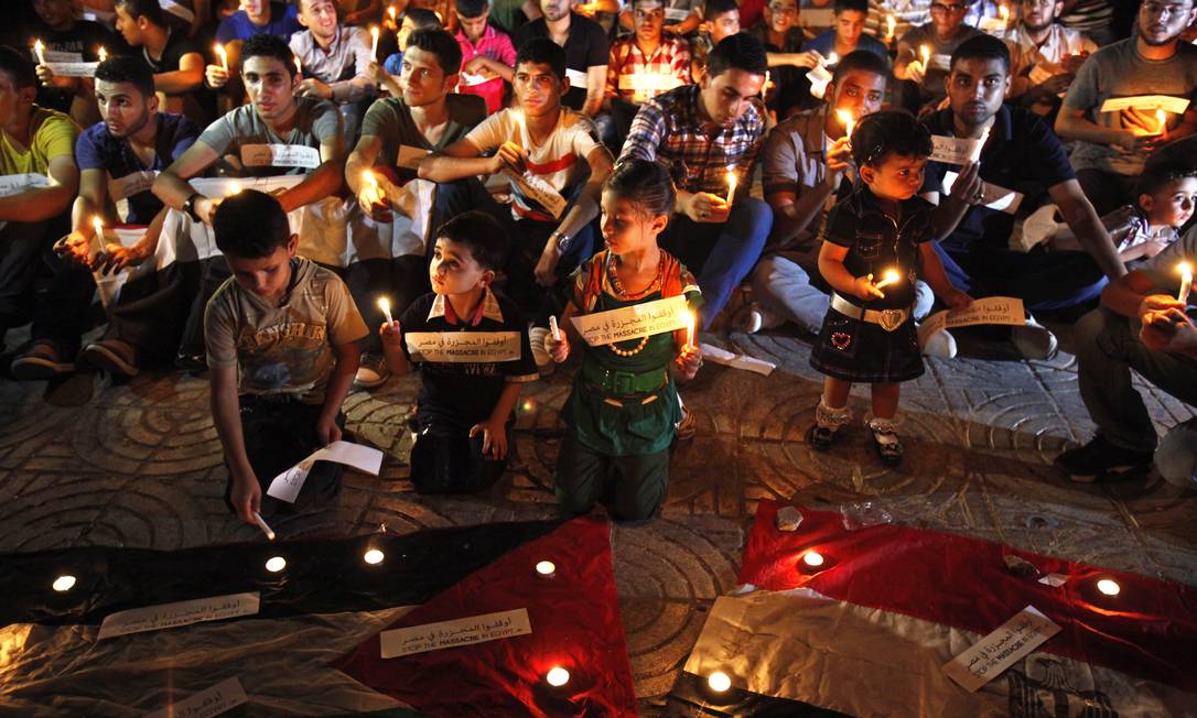 
Palestinos acedem velas e fazem orações em memória dos islamistas mortos no Egito
Foto:
Adel Hana
/
AP
