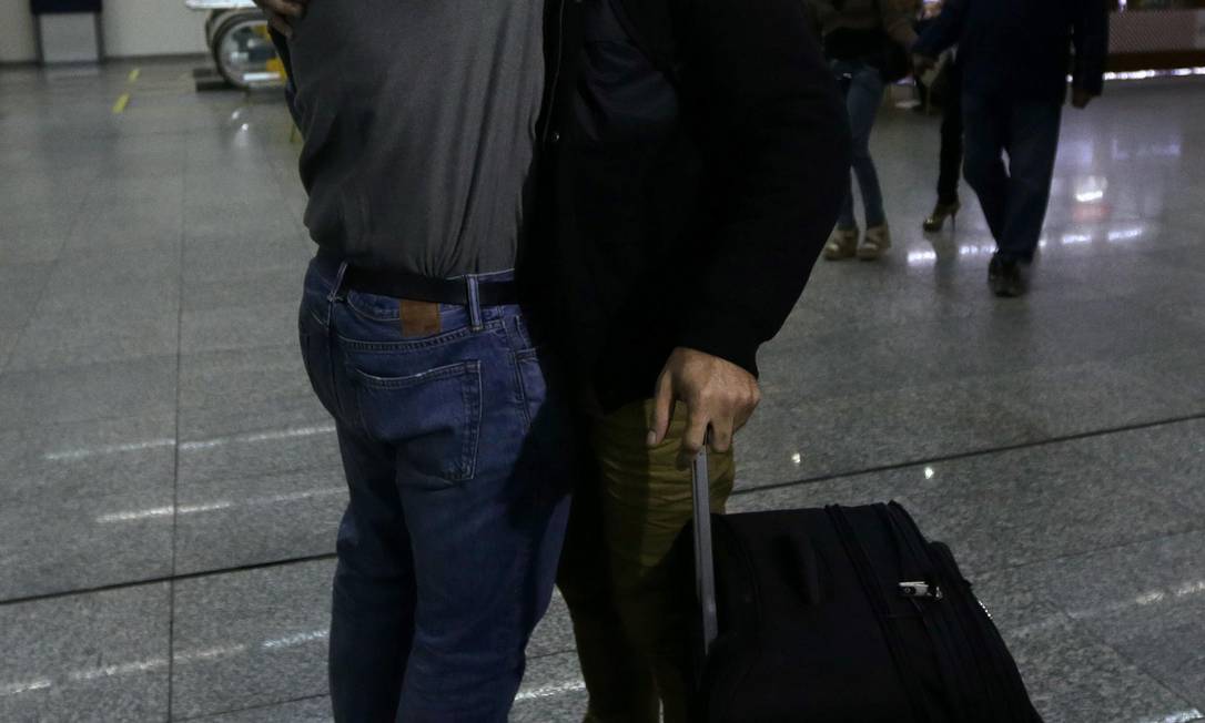 Glenn Greenwald (à esquerda) abraça David Miranda na chegada ao Rio Foto: RICARDO MORAES / REUTERS