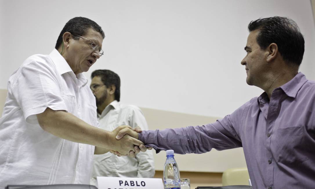 
Negociador das Farc Pablo Catatumbo (à esq.) aperta a mão do negociador do governo colombiano Frank Pearl (à dir.) em encontro em maio
Foto: ENRIQUE DE LA OSA / REUTERS