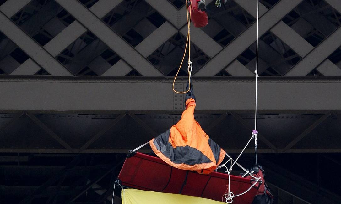 Bombeiro conversa com o ativista da Greenpeace pendurado na Torre Eiffel, em Paris, capital da França Foto: Christophe Ena / AP