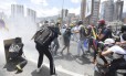 Manifestantes contra Maduro se protegem de gás lacrimogêneo com máscaras