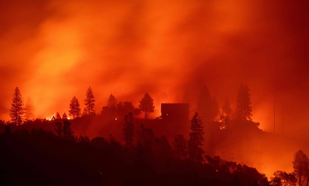 Cases no alto de colina são cercadas pelas chamas no incêndio Camp, no Norte da Califórnia Foto: JOSH EDELSON / AFP