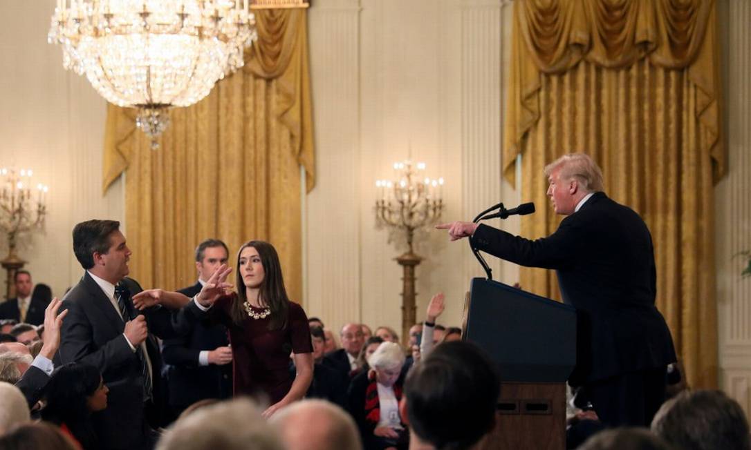 Uma estagiária da Casa Branca tenta tirar o microfone do repórter da CNN Jim Acosta, enquanto ele faz uma pergunta ao presidente Trump e ouve uma réplica inflamada Foto: Jonathan Ernst / REUTERS