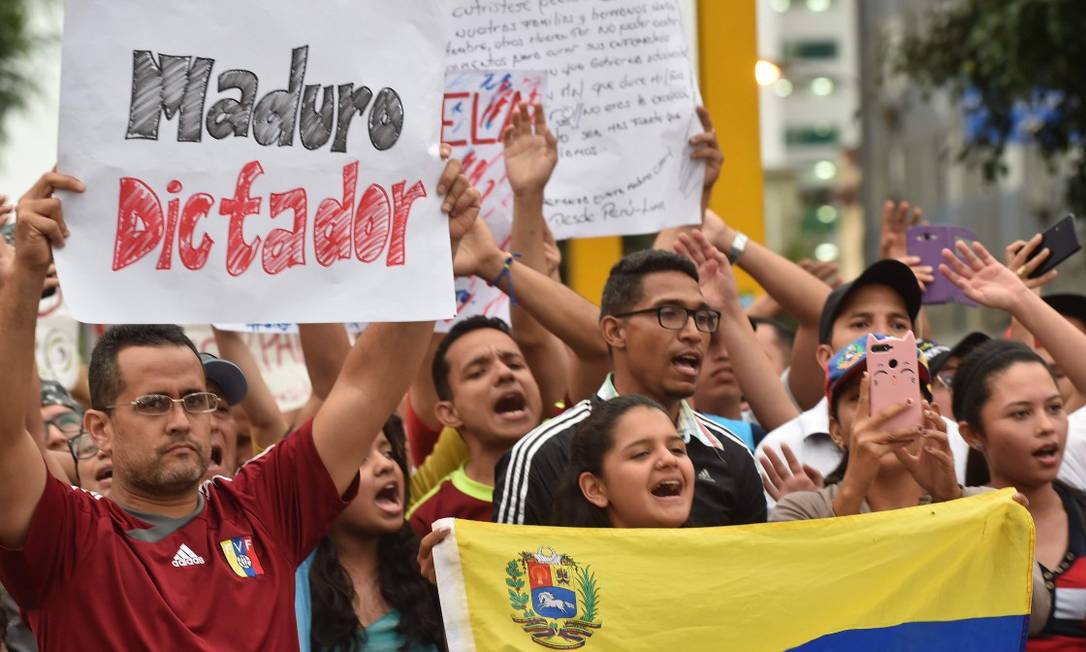 Venezuelanos que moram no Peru protestam em frente à embaixada de seu país em Lima Foto: CRIS BOURONCLE / AFP