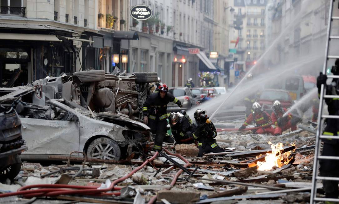 Bombeiros tentam apagar o fogo depois da explosão em uma padaria na esquina das ruas Saint-Cecile e Rue de Trevise, em Paris Foto: THOMAS SAMSON / AFP