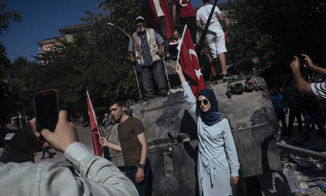 Turcos posam para fotos em tanque de guerra destruído após tentativa de golpe de Estado, em julho de 2016 Foto: EMIN OZMEN/NYT