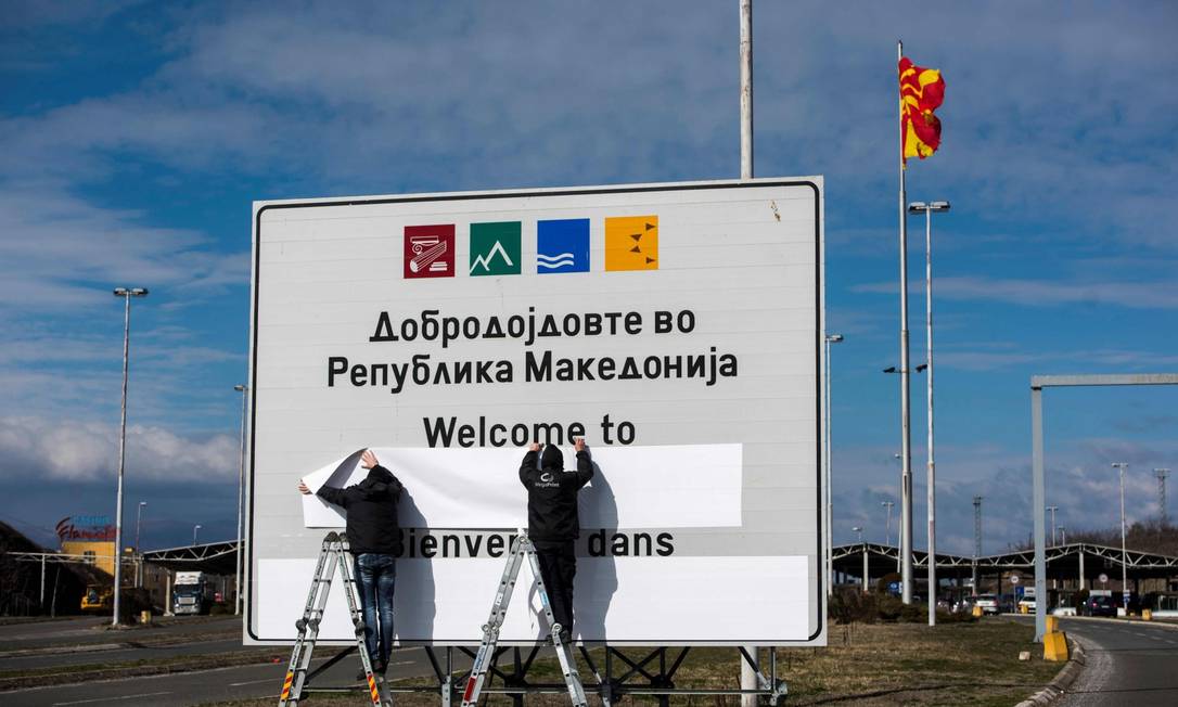 Funcionários trocam o nome da Macedônia do Norte na fronteira com a Grécia Foto: ROBERT ATANASOVSKI/AFP