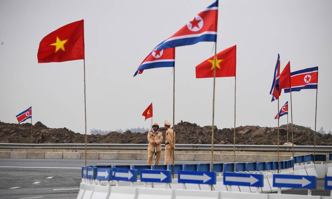 Equipes de segurança perto das bandeiras de Coreia do norte e Vietnã em frente a uma fábrica da Vinfast, a primeira fabricante de carros vietnamita Foto: NOEL CELIS / AFP 26-02-19