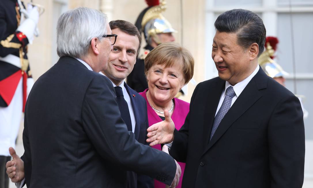 Xi Jinping cumprimenta o presidente da Comissão Europeia, Jean-Claude Juncker, observados por Macron e Merkel Foto: LUDOVIC MARIN / AFP