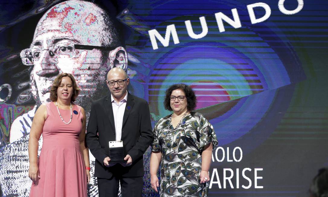 Paolo Parise recebe o Prêmio Faz Diferença das mãos da editora-executiva Fernanda Godoy e da editora de Mundo, Claudia Antunes Foto: Márcio Alves / Agência O Globo