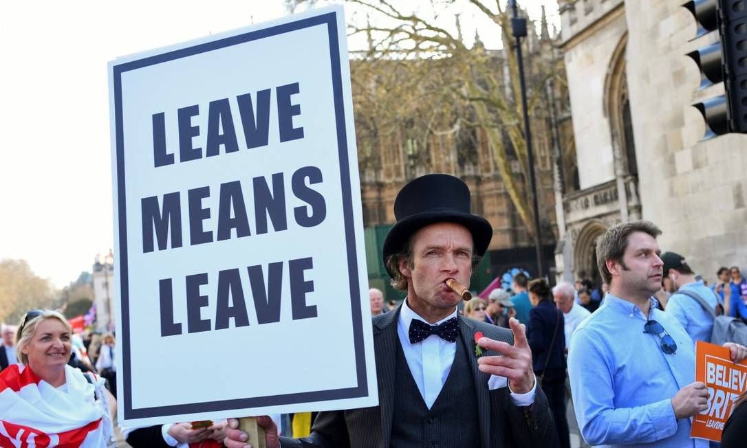 Manifestante com cartaz onde se lê "sair significa sair" em frente ao Parlamento britânico Foto: DYLAN MARTINEZ / REUTERS 29-03-19
