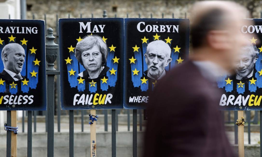 Cartazes da primeira-ministra britânica Theresa May e do líder trabalhista Jeremy Corbyn em frente ao Parlamento em Londres Foto: TOLGA AKMEN / AFP 03-04-19